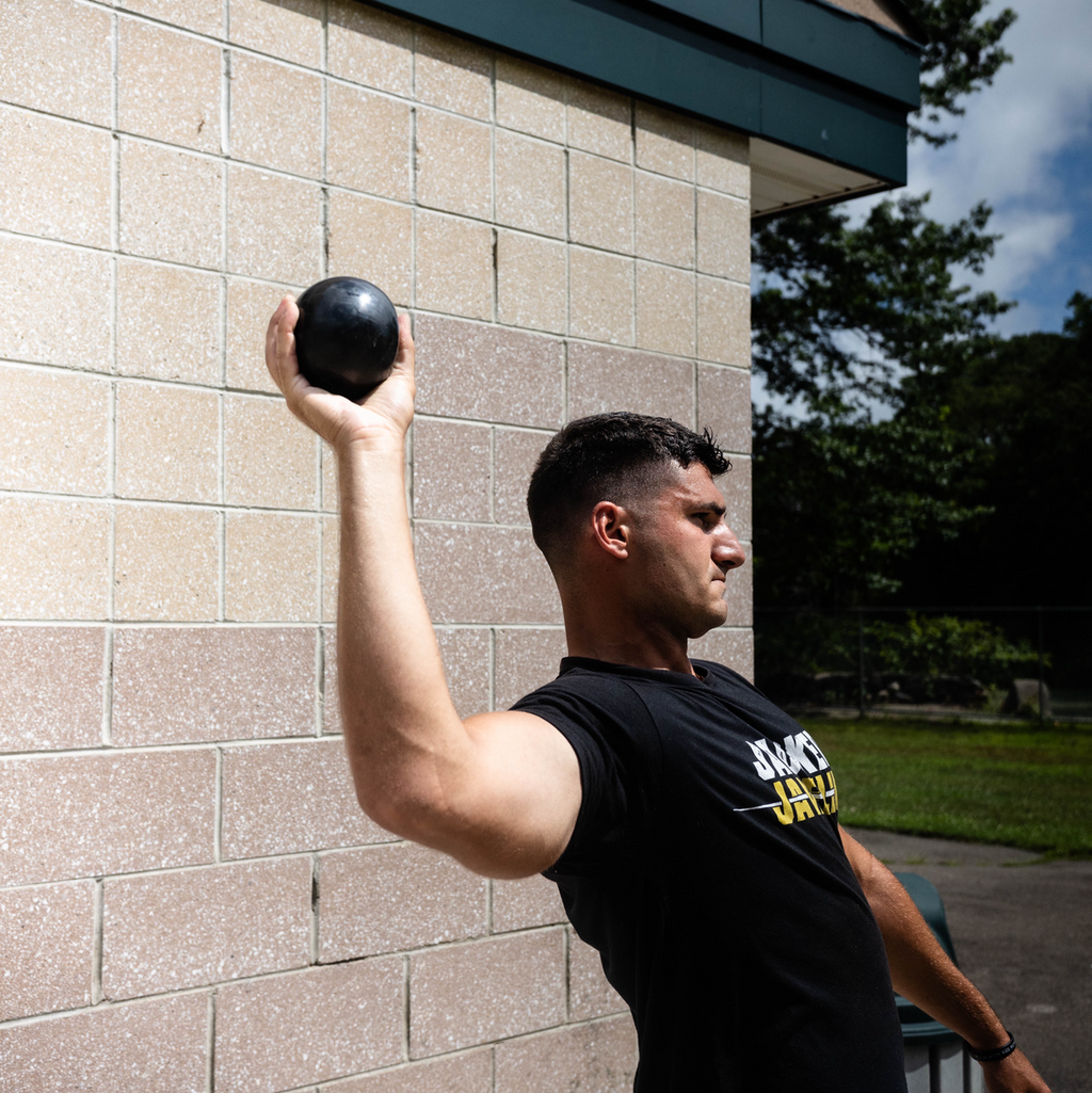 Heavy kit of three Jacked Javelin weighted plyo balls on a dark studio surface, overload strength set